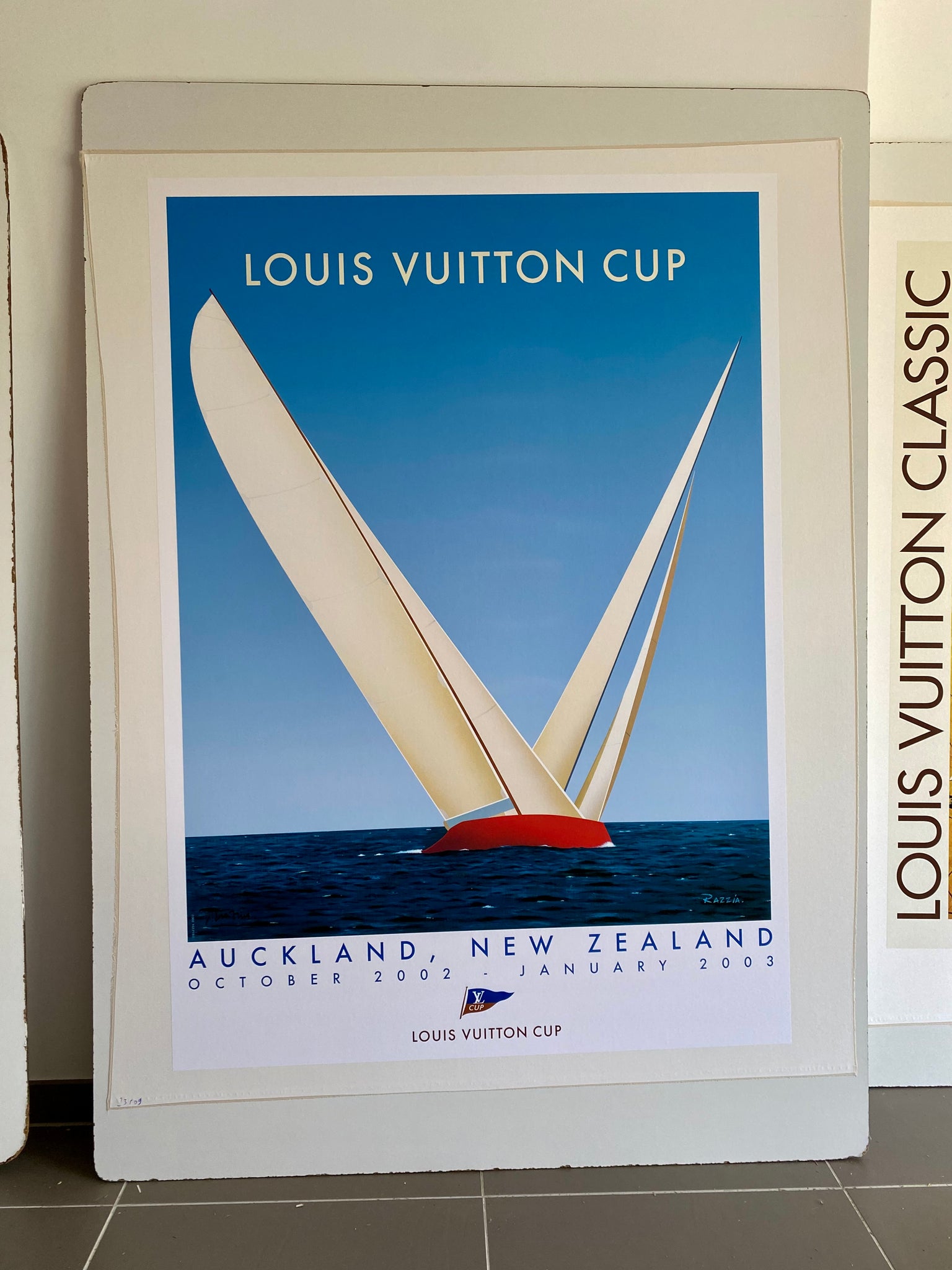 Affiche  Louis Vuitton Cup - Auckland New Zeland Par Razzia, 2002    Affiche originale de Gerard Courbouleix alias Razzia, pour la Louis Vuitton cup  se déroulant à Auckland en Zélande, entre octobre 2002 et Janvier 2003.    L'affiche est signée en bas à droite par la main de l'artiste