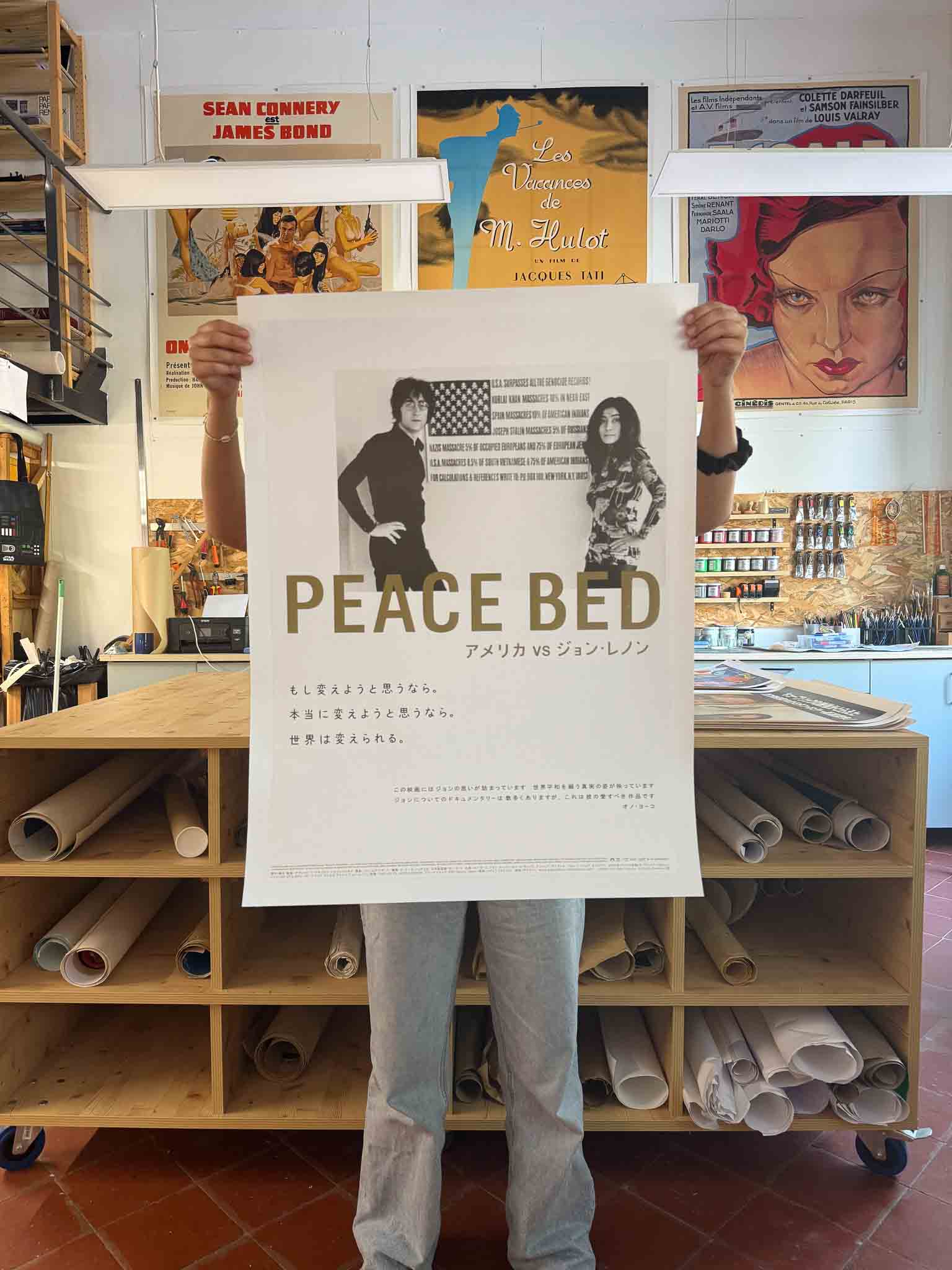 Affiche japonaise du documentaire Peace Bed: America vs John Lennon avec John Lennon et Yoko Ono en noir et blanc devant un drapeau américain modifié