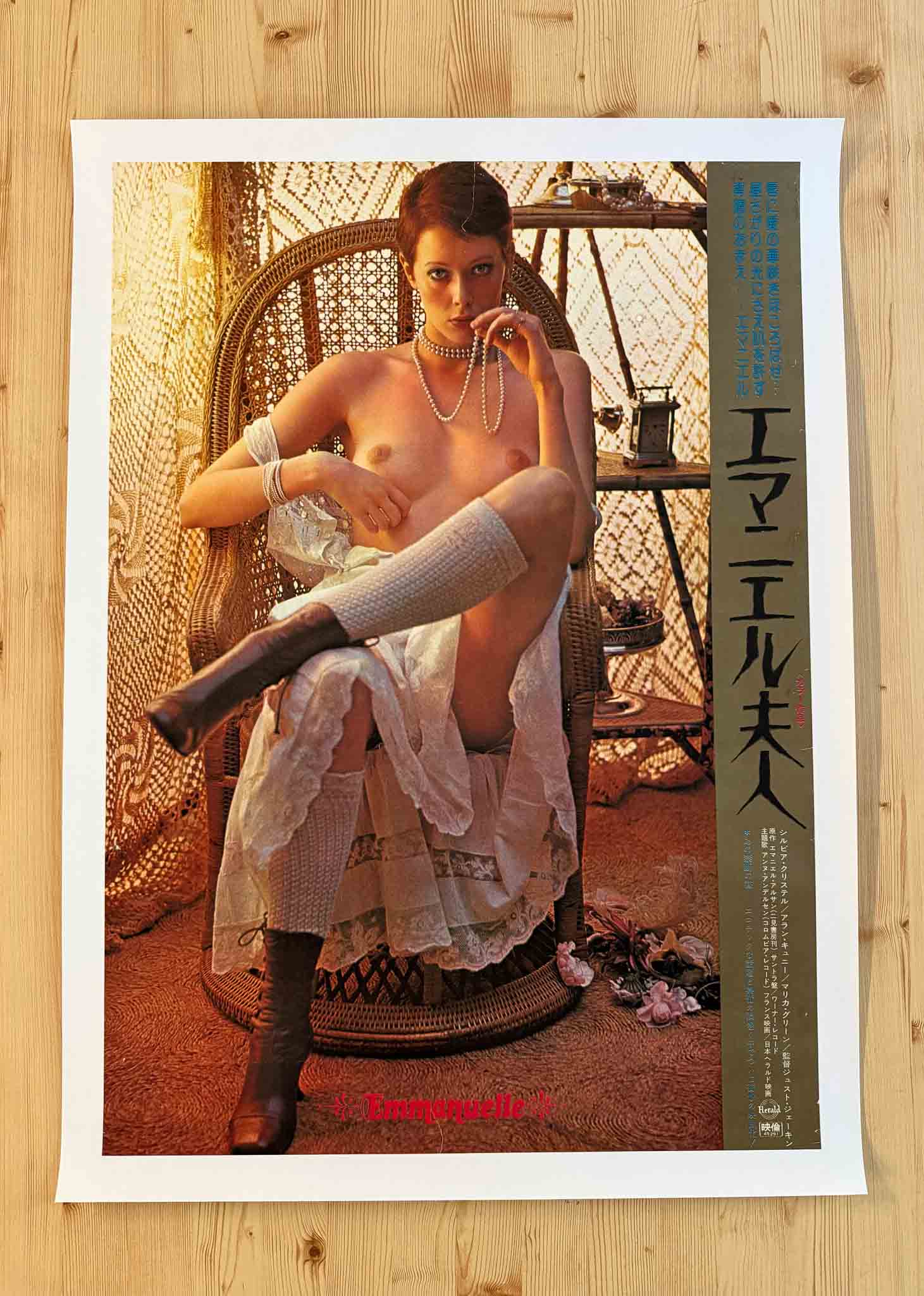 Affiche japonaise du film Emmanuelle (1974) montrant Sylvia Kristel assise en lingerie dans un décor exotique et sensuel