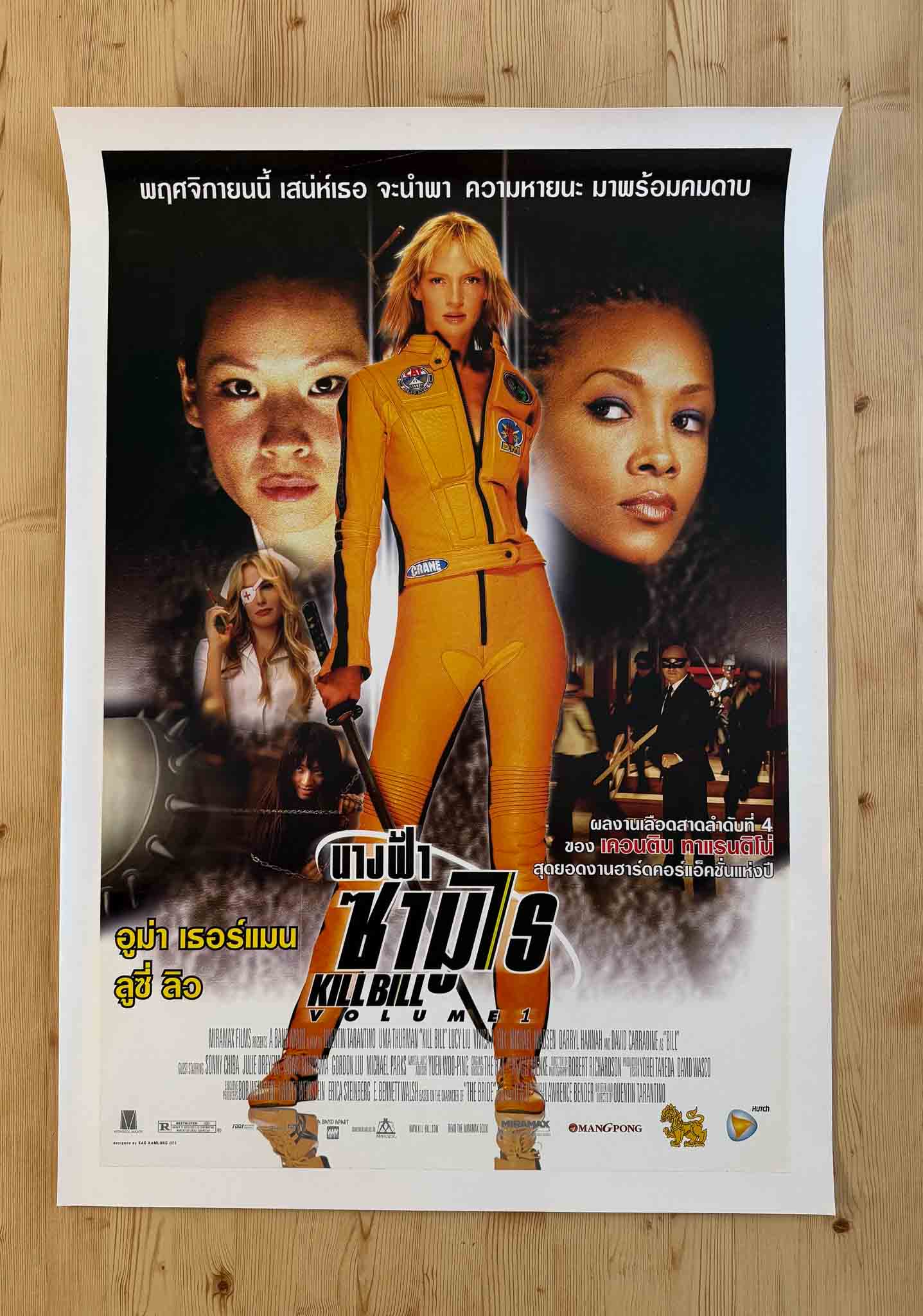 Affiche thaïlandaise de Kill Bill Volume 1 avec Uma Thurman en combinaison jaune entourée des personnages du film, style action asiatique