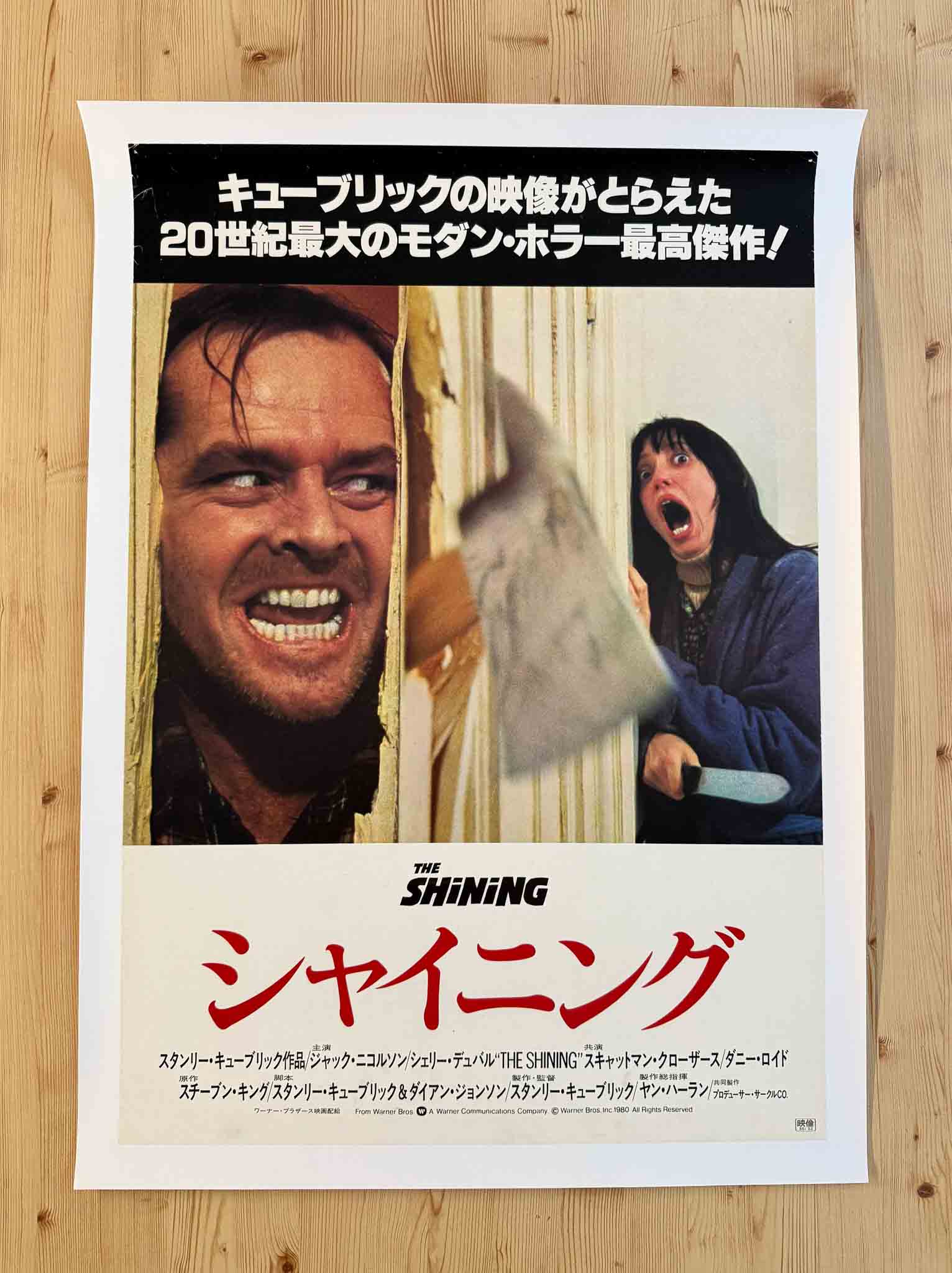 Affiche japonaise du film The Shining avec Jack Nicholson hurlant à travers une porte et Shelley Duvall terrifiée