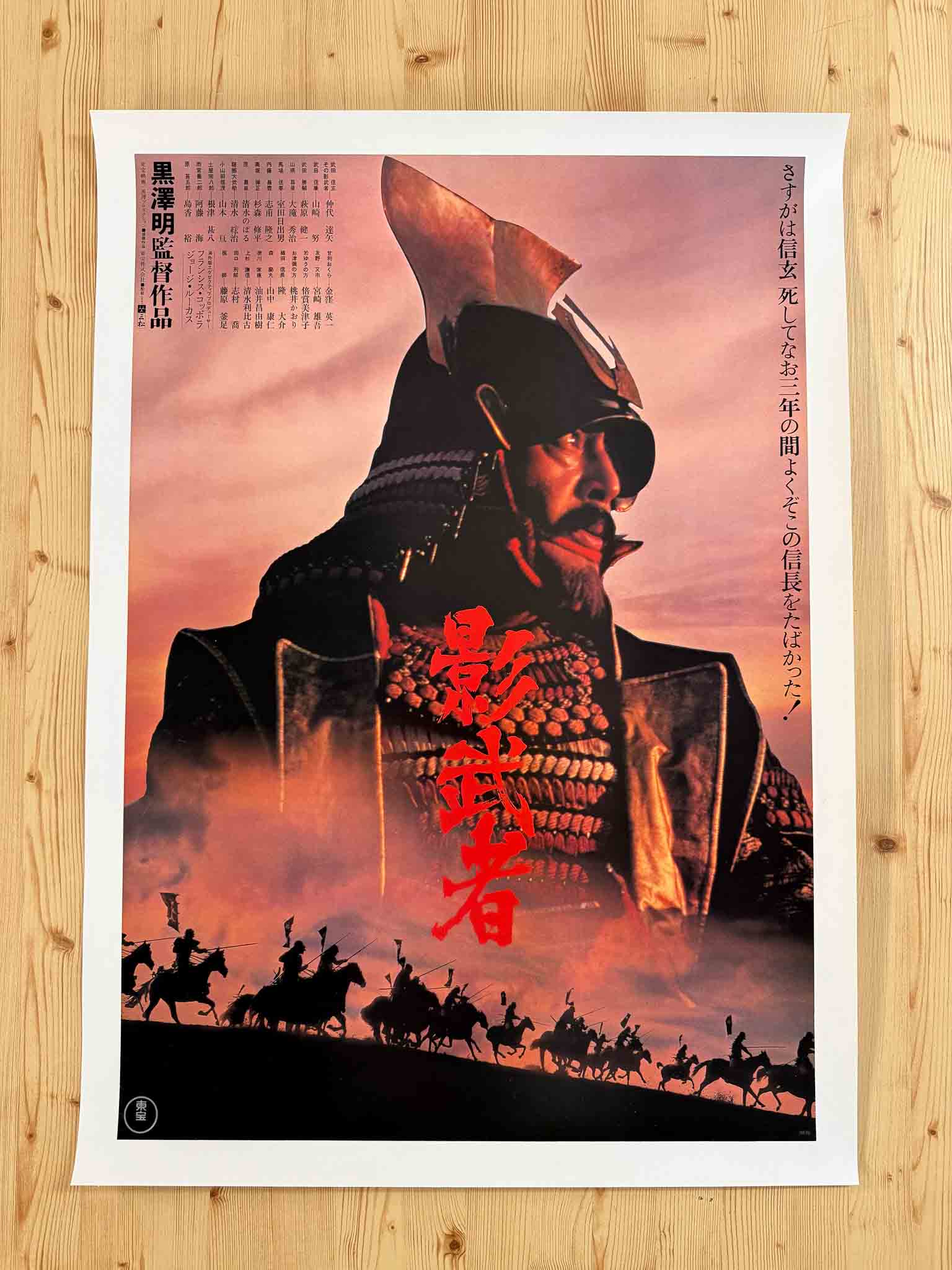 Affiche japonaise du film Kagemusha (1980) montrant un samouraï en armure sur fond rouge dramatique avec silhouettes de cavaliers