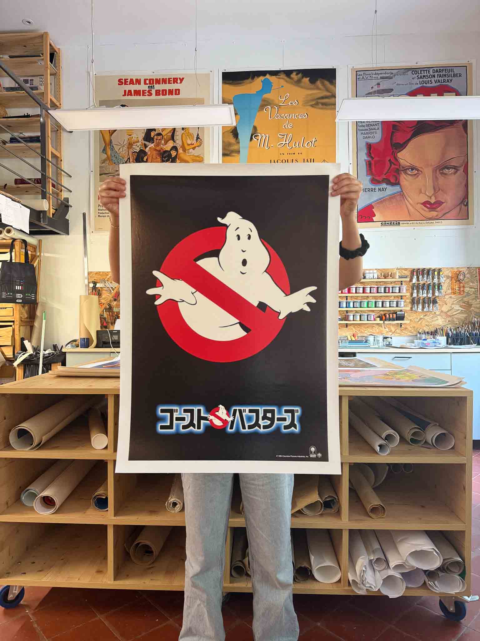 Affiche teaser japonaise du film Ghostbusters avec le logo du fantôme barré et le titre en japonais sur fond noir